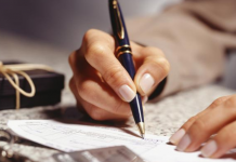 3 maneiras de melhorar suas finanças na véspera de ano novo escrevendo em um papel de finanças